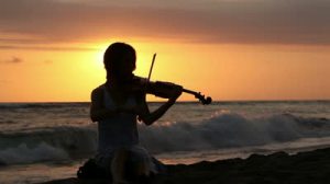 stock-footage-silhouette-of-woman-playing-romantic-music-on-violin-on-shore